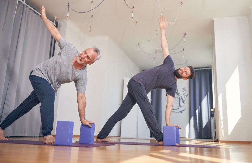 smiling barefoot men performing a yoga exercise